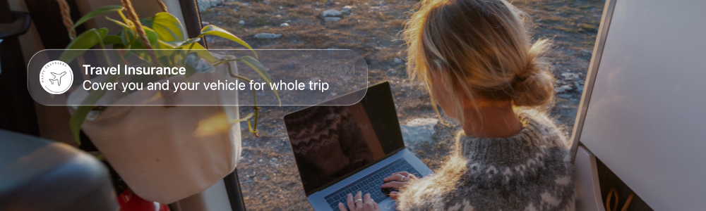 Person working on a laptop outdoors, representing embedded insurance available anytime, anywhere